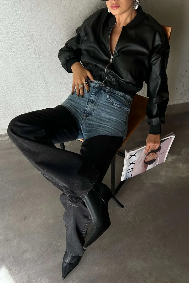 Woman wearing two-tone blue and black wide-leg jeans, black leather jacket, and heeled boots