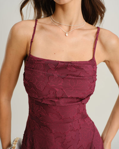 Maroon lace dress worn by a person on a plain background